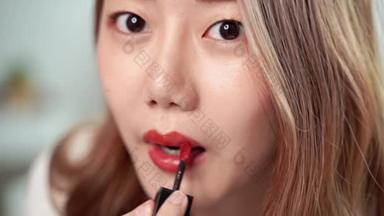 慢动作特写视频，漂亮的亚洲女人正在用漆刷，在嘴边涂口红